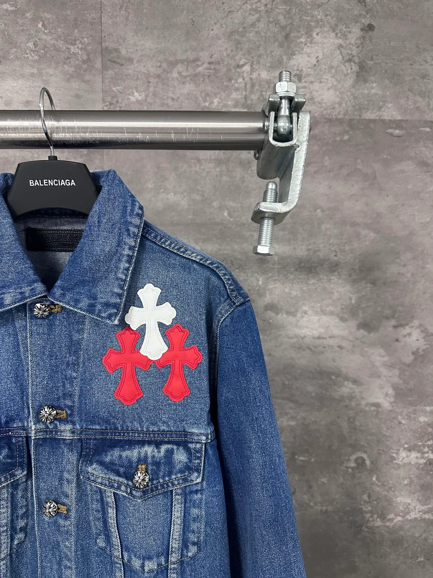 P720 CHrome Hearte cross patchwork leather denim jacket size: S M L Design details: the visual fantasy of Gothic symbols, the multi-dimensional expression of the cross totem: the red and white contrasting cross patches are staggered on the chest and back, making the brand more recognizable; the hollow cross pattern leather splicing on the sleeves combines the mystery of religious symbols with the punk-style deconstructed design. Every detail tells the dark aesthetics of Crowe's heart. Retro distressing with denim texture: Selected denim fabrics are treated with distressing techniques to show natural fading and texture, which not only retains the retro accent of denim items, but also adds a casual sense to the overall look. The ingenuity of hardware and tailoring: The metal buttons and hardware all have Croxin's iconic pattern, which shines exquisitely under the refraction of light; the neat tailoring of the classic denim jacket is suitable for a variety of wearing scenarios, and can create a strong personal style whether it is layered or worn alone. Croxin's denim jacket is not only a piece of clothing, but also a style badge that highlights unique aesthetics and rebellious attitude. For those who pursue individuality, they can leave their own hardcore mark in the fashion field.